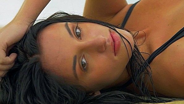 Роскошная брюнетка кокетливо позирует в бассейне